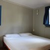 Una camera da letto con pareti grigie, letto matrimoniale, finestre blu e cassettiera.