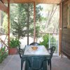 Veranda con tavolo in marmo e sedie, circondata da piante rigogliose.