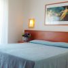 Camera da letto con letto matrimoniale, quadri e lampade a parete.