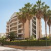 Edificio moderno con balconi curvi e palme.