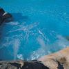 Vasca idromassaggio con rocce e acqua blu brillante.