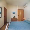 Una camera da letto con letto matrimoniale, specchio grande e aria condizionata.