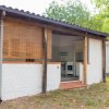 Una piccola casa bianca con patio e stuoia in bambù davanti alla cucina aperta.