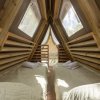 Interno di una tenda A-frame con due letti e asciugamani.