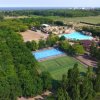 Vista aerea di un parco con piscine, campi sportivi e alberi.