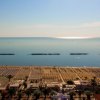 Spiaggia vista dall'alto con mare calmo.