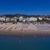 Spiaggia sabbiosa con ombrelloni e bagnanti.