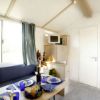 Soggiorno con divano blu, tavolo apparecchiato e una piccola area cucina con microonde.