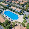Vista aerea di un ampio complesso con piscina, circondato da edifici e verde.
