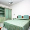 Camera da letto con mobili in legno verde e copriletto coordinato.