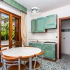 Cucina con tavolo rotondo e sedie, tende beige.