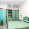 Camera con letto verde, armadio e porta turchese.