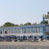 Edificio fronte mare con ombrelloni sulla spiaggia.