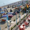 Tavoli e ombrelloni su una terrazza spiaggia.