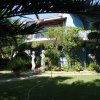 Casa blu con giardino e statue.
