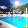 Spiaggia estiva con ombrelloni blu e mare calmo.
