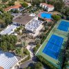 Vista dall'alto su un complesso con campi da tennis, piscine e edifici.