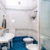 Bagno con pavimento blu, doccia, lavabo doppio e bidet. Piastrelle bianche decorate.