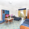 Monolocale con letto, divano blu, tavolo, e balcone.