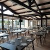 Sala ristorante con tavoli apparecchiati e vetrate.