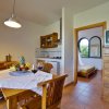 Sala da pranzo con tavolo apparecchiato e cucina aperta.