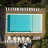 Vista aerea di una piscina con lettini e ombrelloni.