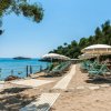 Spiaggia con ombrelloni e sedie a sdraio vicino al mare.