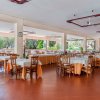 Sala ristorante spaziosa con tavoli apparecchiati di arancione e bianco.