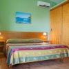 Camera con letto matrimoniale, copriletto a righe colorate e armadio a muro.
