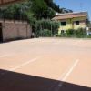Un parcheggio vuoto con un edificio giallo sullo sfondo.