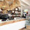 Un bar moderno con cesti di bambù e vetrina di dolci.