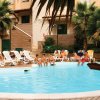 Piscina con sdraio e palme intorno.