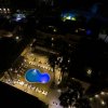 Piscina illuminata di notte circondata da lettini.
