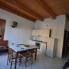 Una cucina moderna con tavolo da pranzo, mobili bianchi e soffitto con travi in legno.