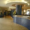 Un'elegante hall d'albergo con colonne blu e un bancone con mosaico.