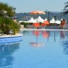 Una piscina con ombrelloni arancioni e palme sullo sfondo.