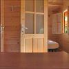 Interno di una cabina in legno con porte e finestre aperte.