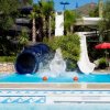 Una piscina con scivoli d'acqua e spruzzi al centro.