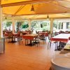 Sala da pranzo esterna con tavoli coperti.