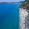 Costa azzurra con spiaggia e strada costiera.