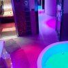 Spa con vasca idromassaggio e sauna in uno spazio colorato.